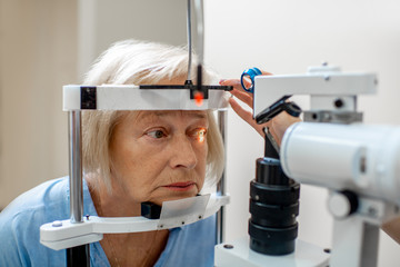 Senior woman during a medical eye examination with microscope in the ophthalmologic office