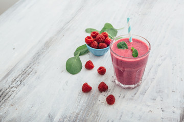 healthy raspberry smoothie on white wooden table with copy space