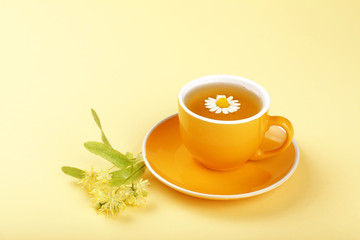 Obraz na płótnie Canvas Yellow cup of herbal tea with camomile