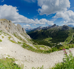 wild mountain landscape with rocky peaks and a hiking trail in the foreground