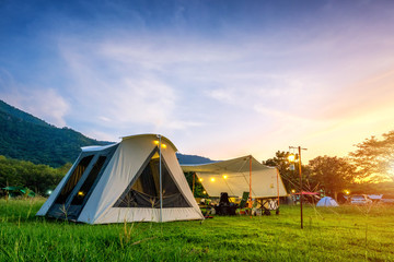 Camping and vintage tent on the green field in the sunset times