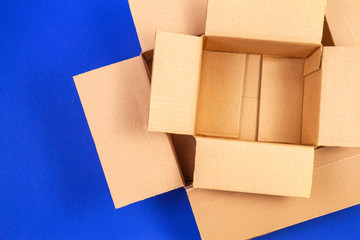 Empty open cardboard boxes on blue background