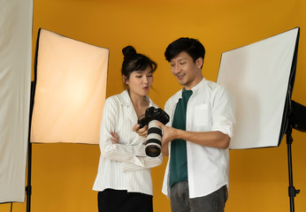 Photographer working with model in studio with equipment
