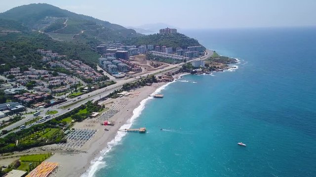 Top view of beach resort town by blue sea. Stock footage. Great place for summer holiday by sea. Modern city with beautiful hotels located on mountain coast