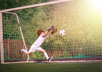 Summer soccer tournament for young kids. football club. emotions and joy of the game. Young goalie. Boy goalkeeper in football sportswear on stadium with ball. Sport concept. selective focus