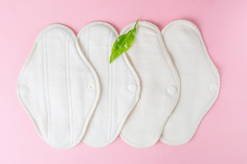 Reusable eco-friendly female pads made of natural fabric with fleece coating for every day. Pink background, place for text, minimalism, top view, flat lay. Zero waste concept