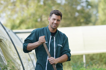 Farmer standing by greenhouse