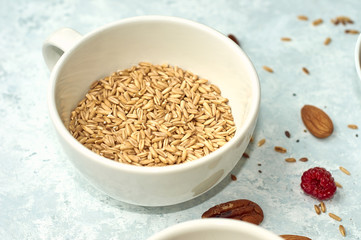 Raw oatmeal in a ceramic cup on the table. Healthy food