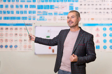 man traffic rules instructor on blurred background of the training room with traffic signs