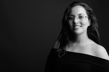 Portrait of young happy woman with eyeglasses smiling shot in black and white