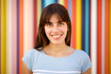Close up front of beautiful young woman smiling against colourful background