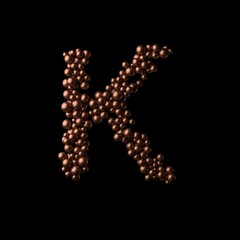 Abstract bronze letter K made of tiny spheres on black background.3D rendering. Fancy alphabet