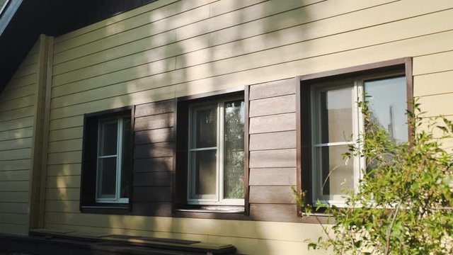 Decoration of houses with siding. Stock footage. Wooden facing of facade of house. Beautiful facade decoration of house made under wooden texture