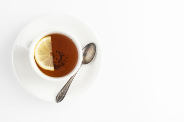 Black tea with lemon and honey on a white background. Hot tea cup isolated, top view flat lay. Flat lay. Autumn, fall or winter drink. Copy space.