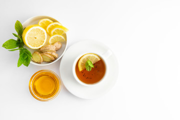 Fresh tea with lemon and honey on a white background. Hot tea cup isolated, top view flat lay. Flat lay. Autumn, fall or winter drink. Copy space.