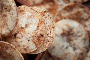 Brown rice chips in wooden bowl. Healthy crispy snack