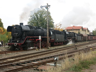 Fototapeta na wymiar Zwei Dampfloks mit Güterzug verlassen den Bahnhof