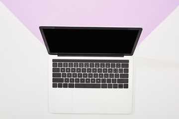 top view of laptop with blank screen on violet and white background