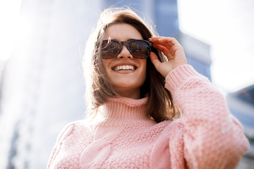 Wonderful caucasian woman in sunglasses playfully posing on the street. Outdoor photo of inspired young lady making selfie
