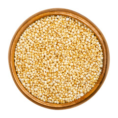 Puffed quinoa in wooden bowl. Popped seeds of Chenopodium quinoa, a pseudocereal, used like breakfast cereals and in the form of rice cakes. Closeup, from above, over white, isolated macro food photo.