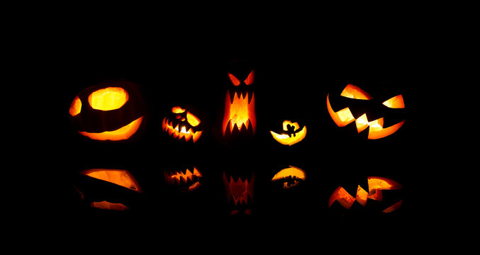 Image of halloween pumpkins with burning mouths on blank black background.