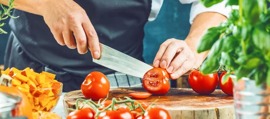 Fotobehang Koch schneidet frische rote Tomaten in Restaurant küche  © karepa