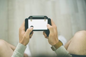 Close up photo of man playing at smartphone, empty phone screen
