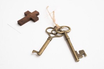 Old vintage brass key with cross tag on white background