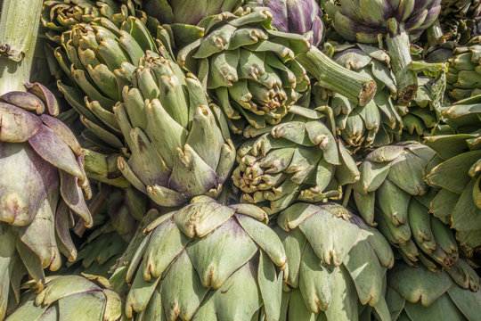 background of fresh juicy artichokes in the market close up
