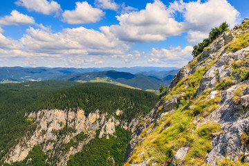 Top hill mountain landscape with blue sky and clouds.
