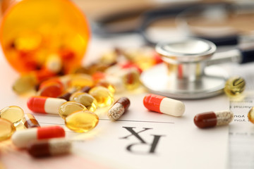 Pile of tablets lying over prescription application form