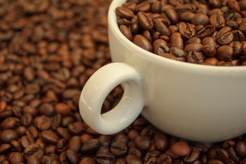 cup with coffee beans and cinnamon sticks	