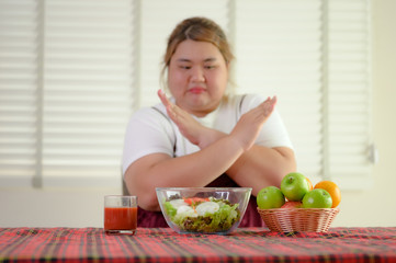 salad vegetable and fruit on table refused or anti to eat by plump fatty woman, do not wants to eat salad food, against vegeteble green salad, unpreferable fruit vegetable salad