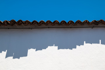 Edge of the roof with its shadow on a white wall
