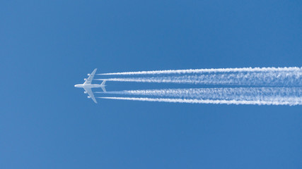 four-engined jet aircraft, jet airbus a380 airplane in the sky with condensation stripes © André Gerken