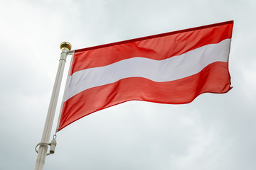 flag of Latvia in the wind in the daylight against sky