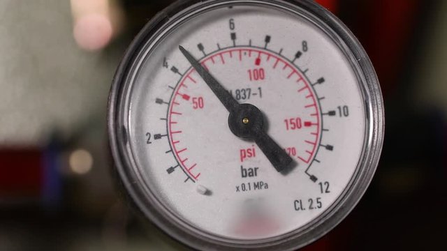 Pressure gauge in a factory, arrow movement on an industrial pressure gauge. Industrial pressure gauge