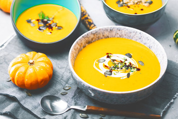 close-up view of pumpkin soup puree in bowls, corn and pumpkins on table