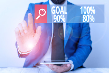 Writing note showing Goal 100 Percent 90 Percent 80 Percent. Business concept for Percentage of your objectives fulfilment success level Businessman with pointing finger in front of him