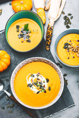 close-up view of pumpkin soup puree in bowls, corn and pumpkins on table