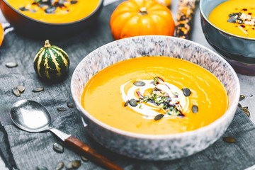 close-up view of pumpkin soup puree in bowls, corn and pumpkins on table