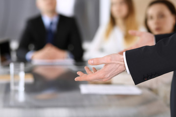 Business presentation. Businessman giving speech to colleagues and partners at corporate meeting or conference, close-up of speaker hands