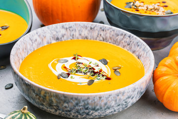 close-up view of pumpkin soup puree in bowls, corn and pumpkins on table