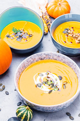 close-up view of pumpkin soup puree in bowls, corn and pumpkins on table