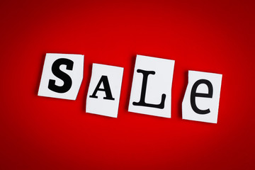 Text SALE on red background of cut out letters. Message on poster, card. Inscription on banner. Shopping concept. Single word, advert.