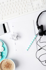 workspace with notebook, phone, coffe and headphones on white background. Flat lay, top view office table desk