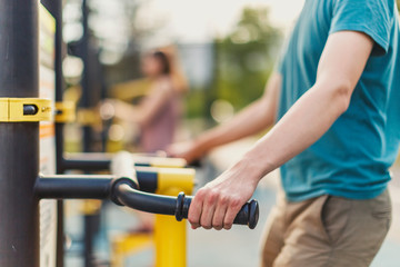 Urban environment: outdoor fitness equipment, Hand of a young man on a simulator