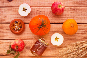 Fresh sliced pumpkin(squash), apples, glass jar of honey on the wooden background. Food, Thanksgiving day concept. Top view. Space for a text. Flat lay. Close up.