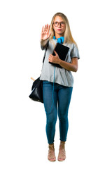 A full-length shot of Student girl with glasses making stop gesture with her hand denying a situation that thinks wrong on isolated white background