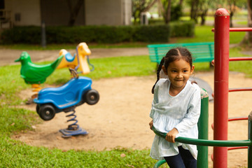 Fototapeta na wymiar An Asian girl plays a slider on the playing field, creating development